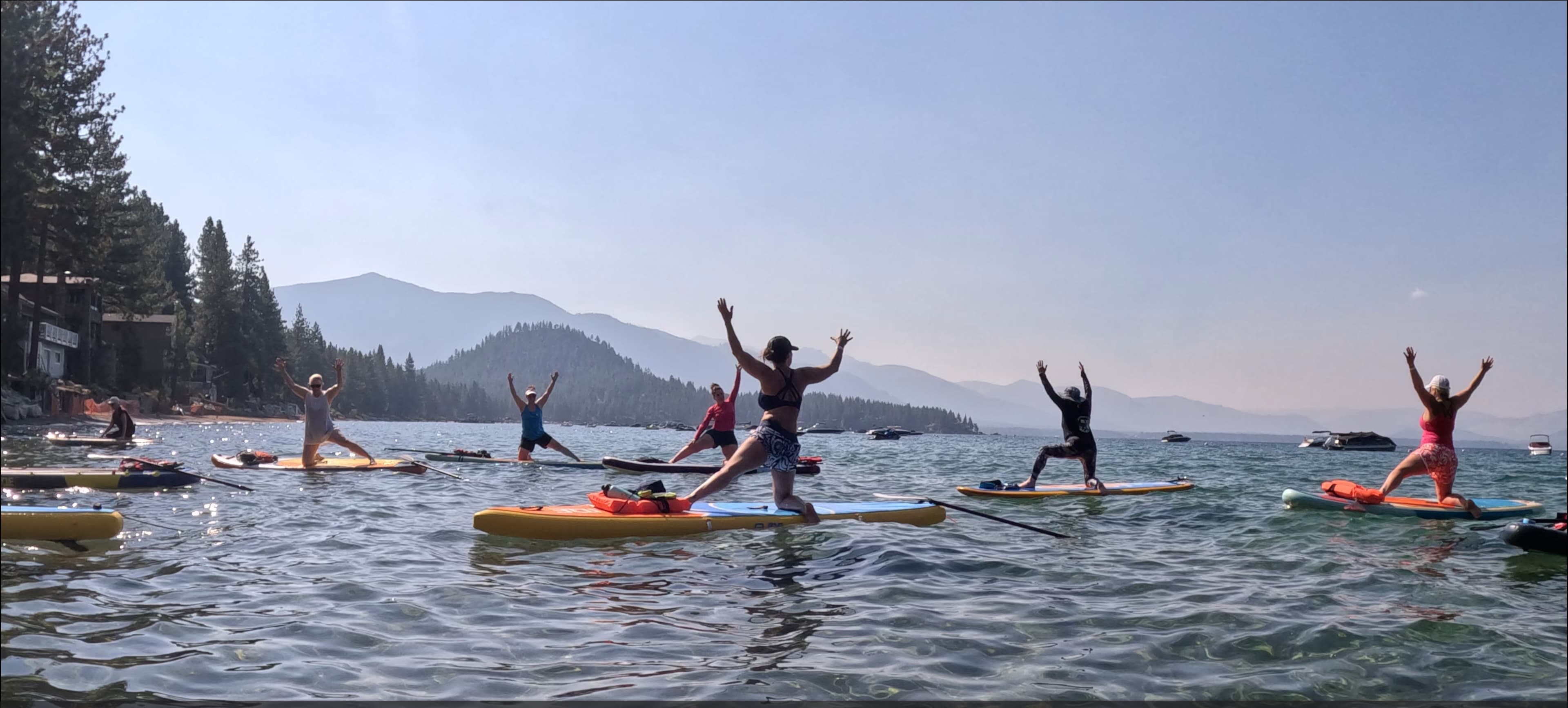 A paddler glides across an alpine lake with granite peaks rising behind.